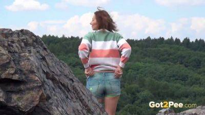 Pretty girl takes a piss while out walking in the country on vidgratis.com