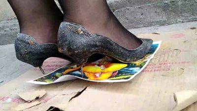 Girl stomping on picture in black metal high heels - India - Pakistan on vidgratis.com